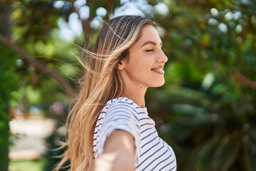 Young blonde woman breathing with closed eyes at park