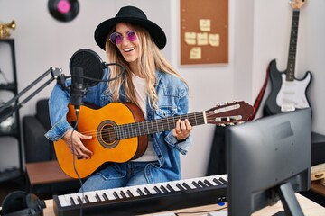 Fototapeta na wymiar Young woman musician singing song playing classical guitar at music studio