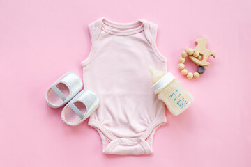 Obraz na płótnie Canvas Baby girl bodysuit with toys and accessories, flat lay