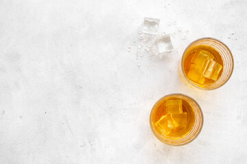 Glass of whiskey or brandy with ice. Strong alcohol background