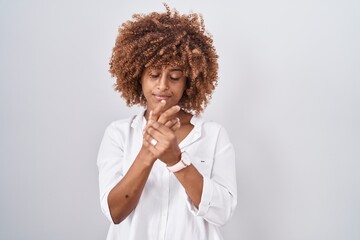 Fototapeta na wymiar Young hispanic woman with curly hair standing over white background suffering pain on hands and fingers, arthritis inflammation