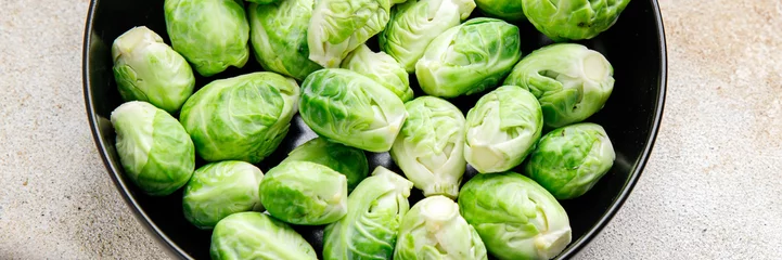 Deurstickers green Brussels sprouts raw vegetable food snack on the table copy space food background  © Alesia Berlezova