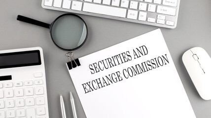 SECURITIES AND EXCHANGE COMMISSION written on paper with office tools and keyboard on the grey...