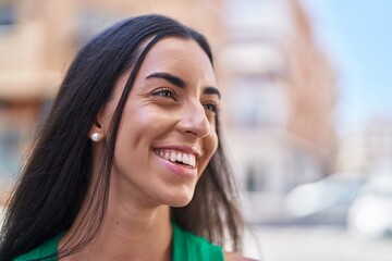 Young beautiful hispanic woman smiling confident looking to the side at street