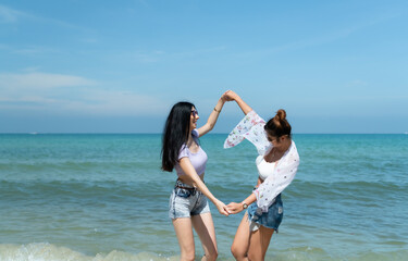 LGBT couples traveling around Asia, Swim happily on the sandy beach with the beautiful blue sea