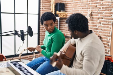 African american man and woman music group singing song playing guitar and tambourine at music...