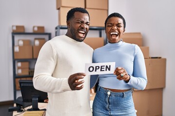 Young african american couple working at small business ecommerce angry and mad screaming frustrated and furious, shouting with anger. rage and aggressive concept.