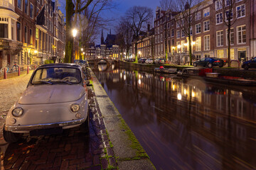 Beautiful old houses on the city waterfront of Amsterdam at sunset.