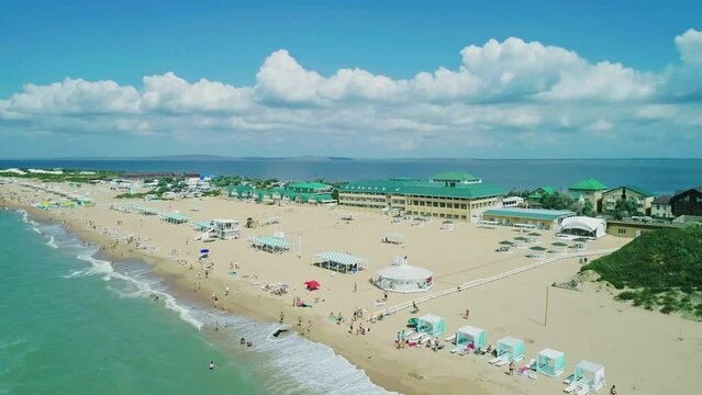 Aerial over the long sandy spit with a beach and azure water on a sunny summer day. Waves crashing to the shore. Relaxing calm atmosphere. Panoramic seascape