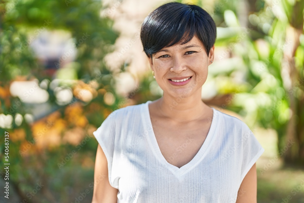 Sticker Middle age chinese woman smiling confident standing at park