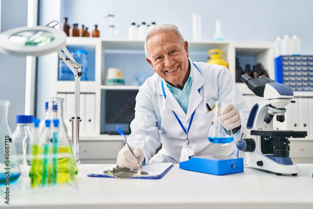 Poster Senior man wearing scientist uniform measuring liquid at laboratory