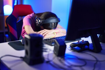 Young chinese woman streamer stressed using computer at gaming room