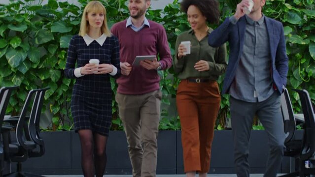 Coworkers on coffe break walking through office space