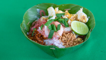 Pad Thai - Birds Eye View, stir fried rice noodle dish in green banana leaves krathong served with lime and spring onion.