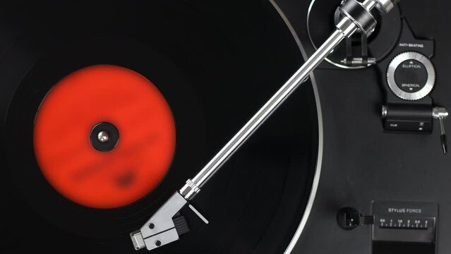 Top view on black turntable with rotating LP record. Gramophone playing vinyl disc, close-up.