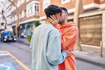 Two man couple hugging each other and kissing at street