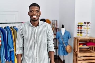 Young african american man working as manager at retail boutique with a happy and cool smile on...