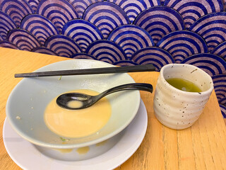 Finished Ramen Noodle Bowl on wooden table with blue japanese background