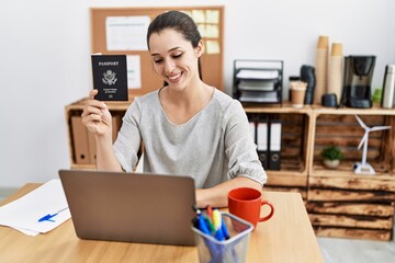 Young hispanic woman holding united states passport working at office