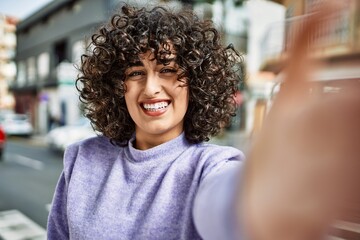 Young middle east woman smiling confident making selfie by the camera at street