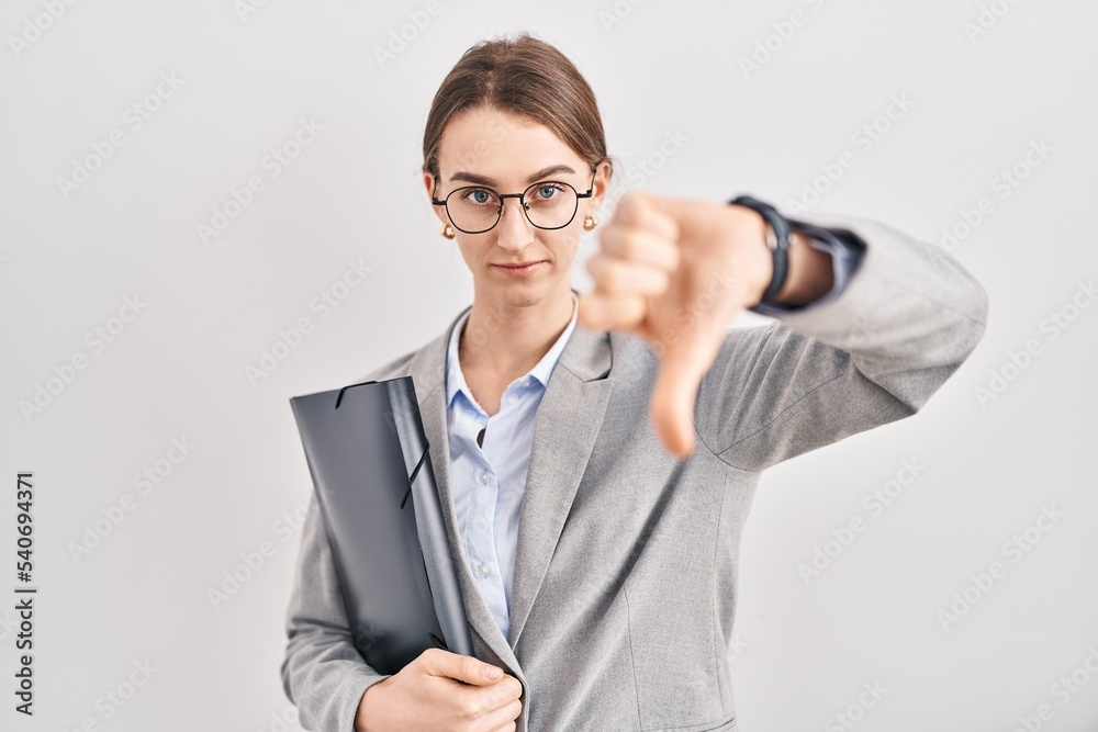 Poster young caucasian woman wearing business clothes and glasses looking unhappy and angry showing rejecti