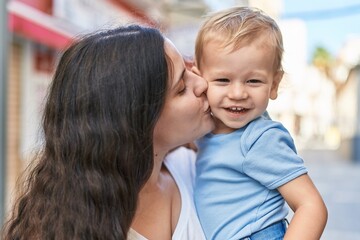 Mother and son smiling confident kissing at street