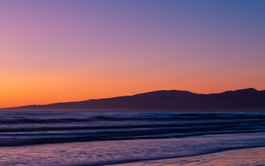 Fototapeta na wymiar Beautiful sunrise view of beach shore and mountains.