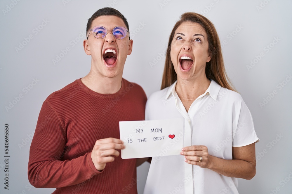 Canvas Prints Mother and son holding my mom is the best card angry and mad screaming frustrated and furious, shouting with anger looking up.