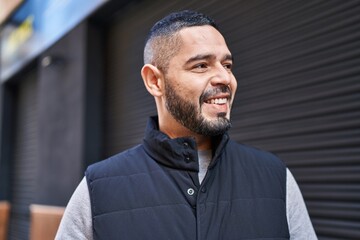 Obraz premium Young latin man smiling confident looking to the side at street
