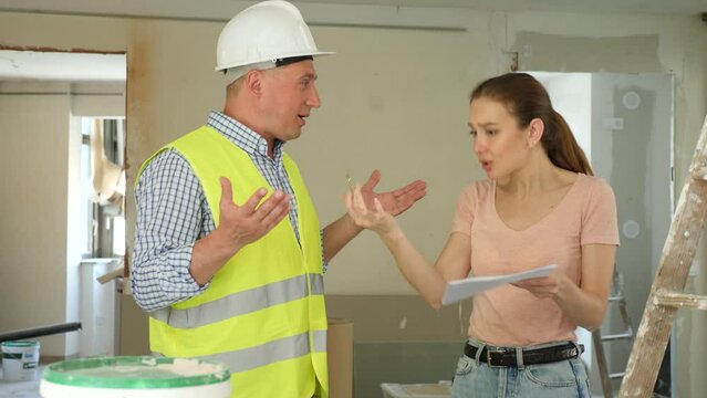 Portrait of perplexed man builder and annoyed gesturing woman, conflict between female architect and contractor at construction site of house being renovated. High quality 4k footage