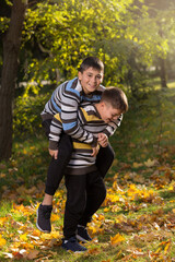 Fototapeta premium Children, two boys have fun in the park in autumn, outdoor activities, lifestyle