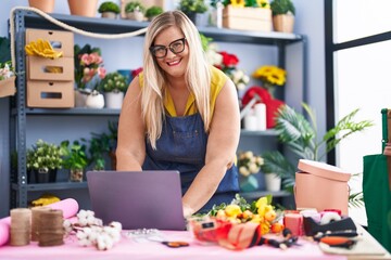 Young woman florist smiling confident using laptop at florist