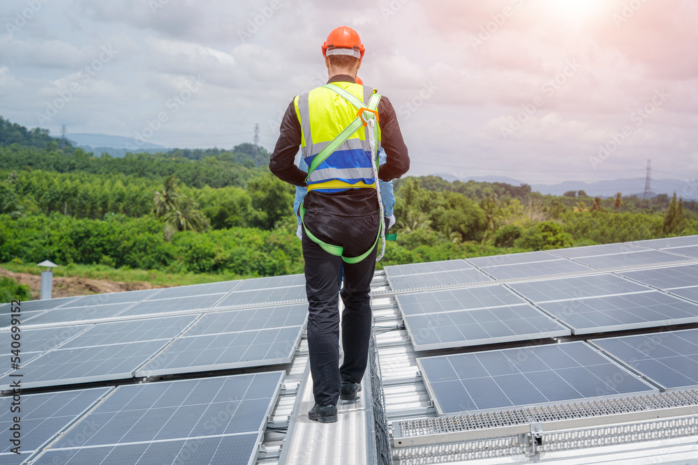 Poster Professional worker installing and checking solar panels on the roof of a factory,Innovative solution for energy solving. Use renewable resources. Green energy.
