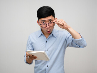 Manager man holding notebook take off his glasses to looking feels amazed isolated