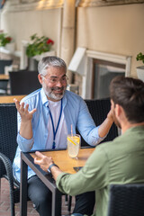 Two men sitting in the cafe and having an interesting conversation