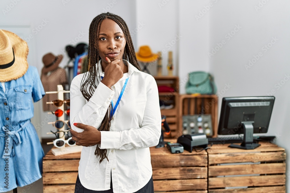 Sticker Black woman with braids working as manager at retail boutique looking confident at the camera with smile with crossed arms and hand raised on chin. thinking positive.