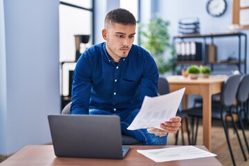 Fototapeta premium Young hispanic man business worker using laptop working at office