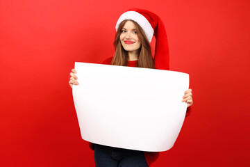 Christmas sale on the eve of the holidays. A young woman with a white poster in her hands on a red...