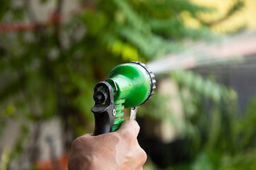 Picture of a gardener using water spray to water the plants.