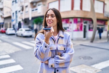 Young beautiful hispanic woman smiling confident talking on the smartphone at street