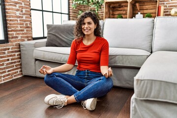 Fototapeta premium Young latin woman smiling confident doing yoga exercise at home