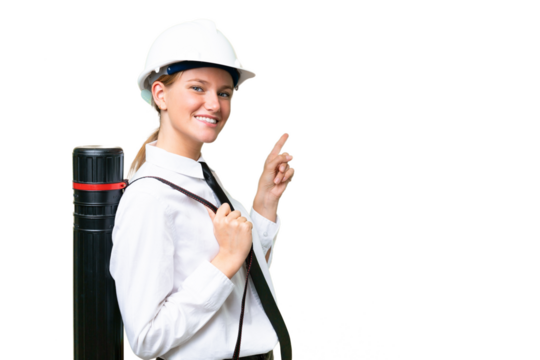 Young architect caucasian woman with helmet and holding blueprints over isolated background pointing finger to the side and presenting a product