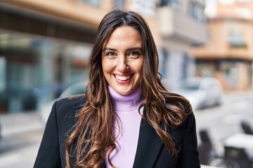 Young hispanic woman smiling confident standing at street