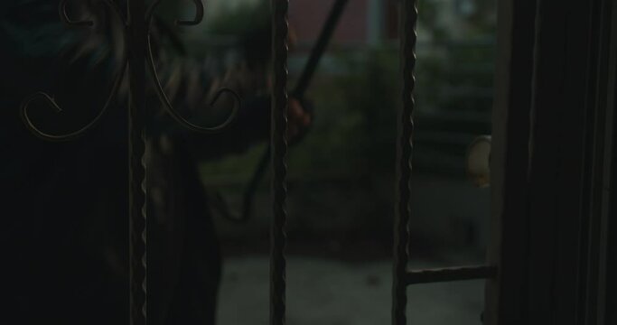 Thief with crowbar entering a house
