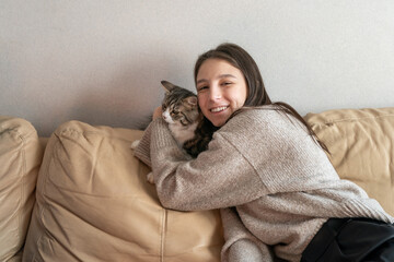 girl sitting on the couch next to her cat