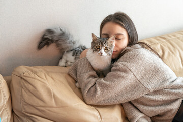 girl sitting on the couch next to her cat