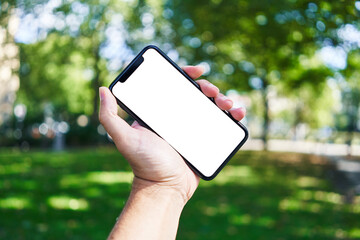 Man holding smartphone showing white blank screen at park