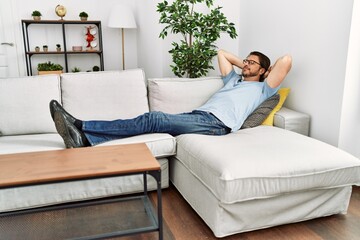 Obraz premium Middle age caucasian man relaxed with hands on head lying on sofa at home