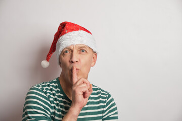 portrait of asenior man in a santa hat on a white background copy space