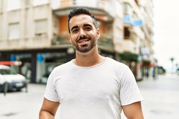 Fototapeta na wymiar Young hispanic man smiling confident walking at street